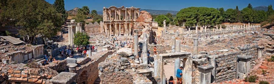 Wide view across the excavated center of Ephesus from the higher ground of the baths, with the Library of Celsus closing the far end