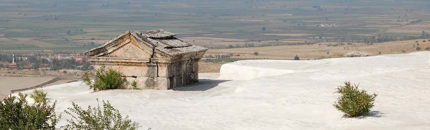 An ancient sarcophagus resting on the white travertines of Hierapolis