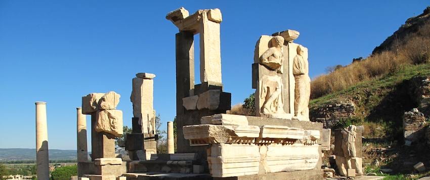 The Memmius Monument in Ephesus, its marble piers and carved figures standing against a clear blue sky