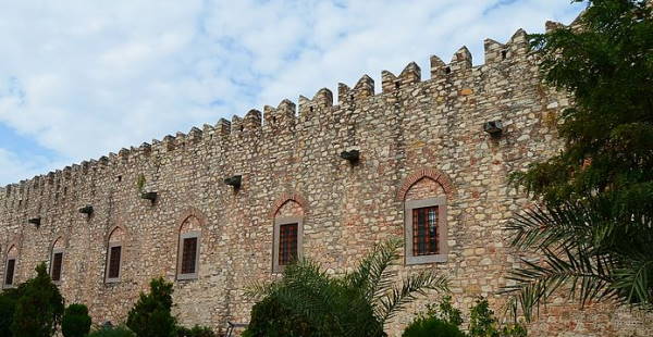 The crenellated stone wall of the Öküz Mehmet Paşa caravanserai in Kuşadası