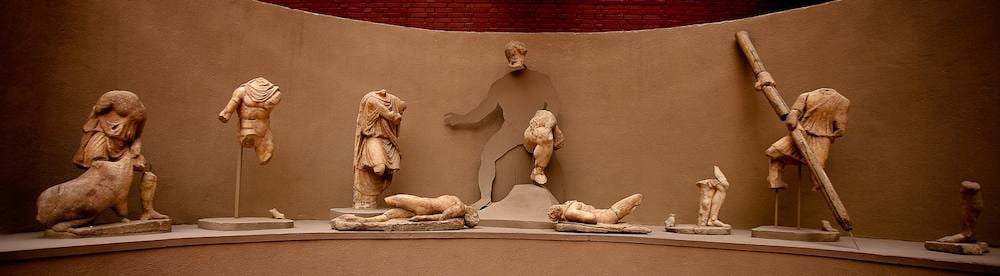 Marble figures of the Polyphemus statue group arranged in a curved niche at the Ephesus Museum